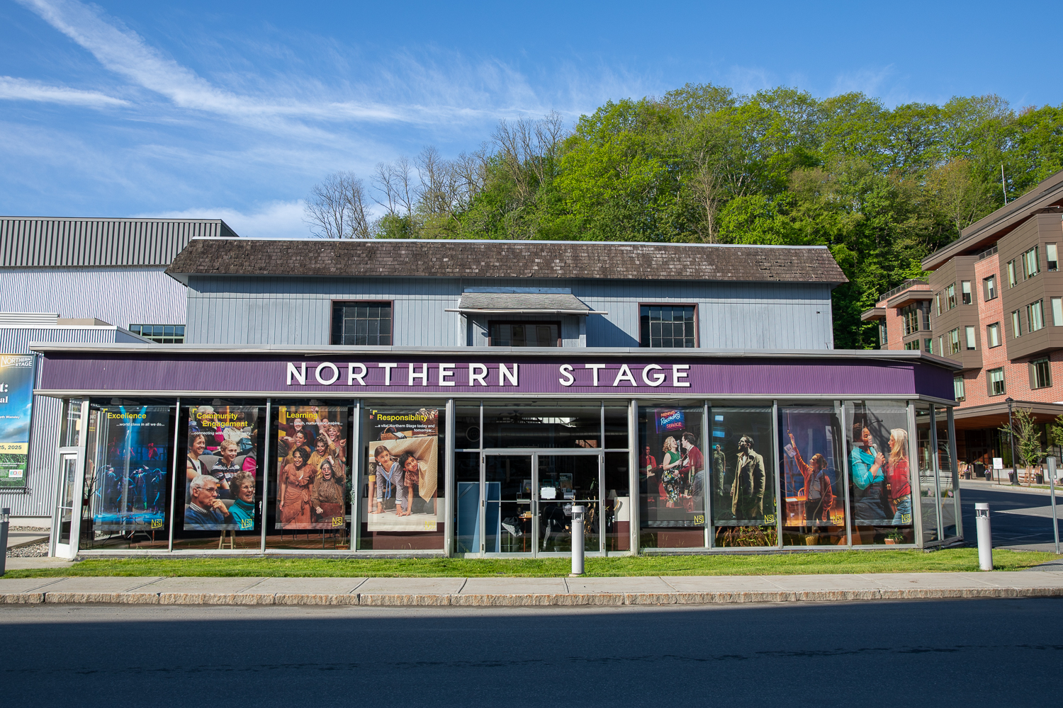 the front of a building ith the words 'Northern Stage' on the front. In the windows are posters for upcoming events.