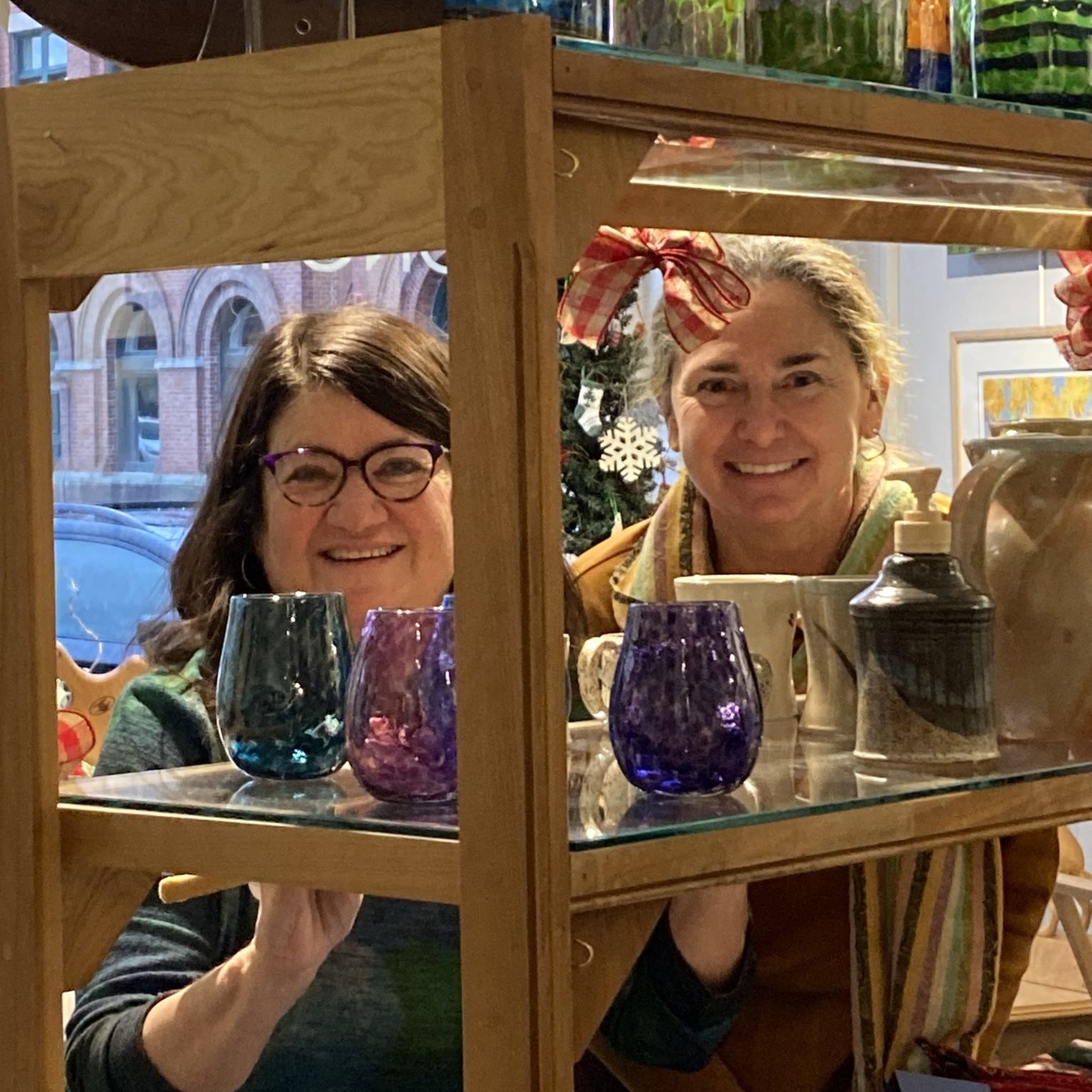 LRG_3419 - Rachel Obbard Two women smiling at the camera through a shelf colorful glassware